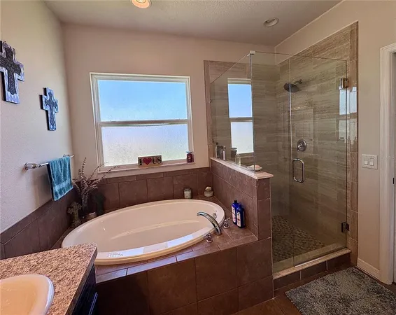 a bathroom with a granite countertop sink mirror and a bathtub