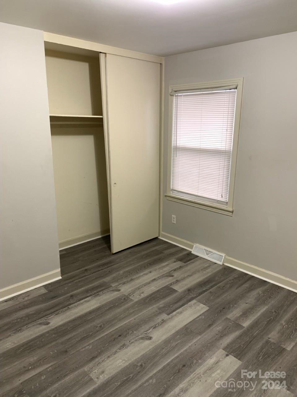 44177 B Mountain View Church Road Albemarle, NC 28001 - Photo 13 of 26 an empty room with wooden floor cabinet and windows
