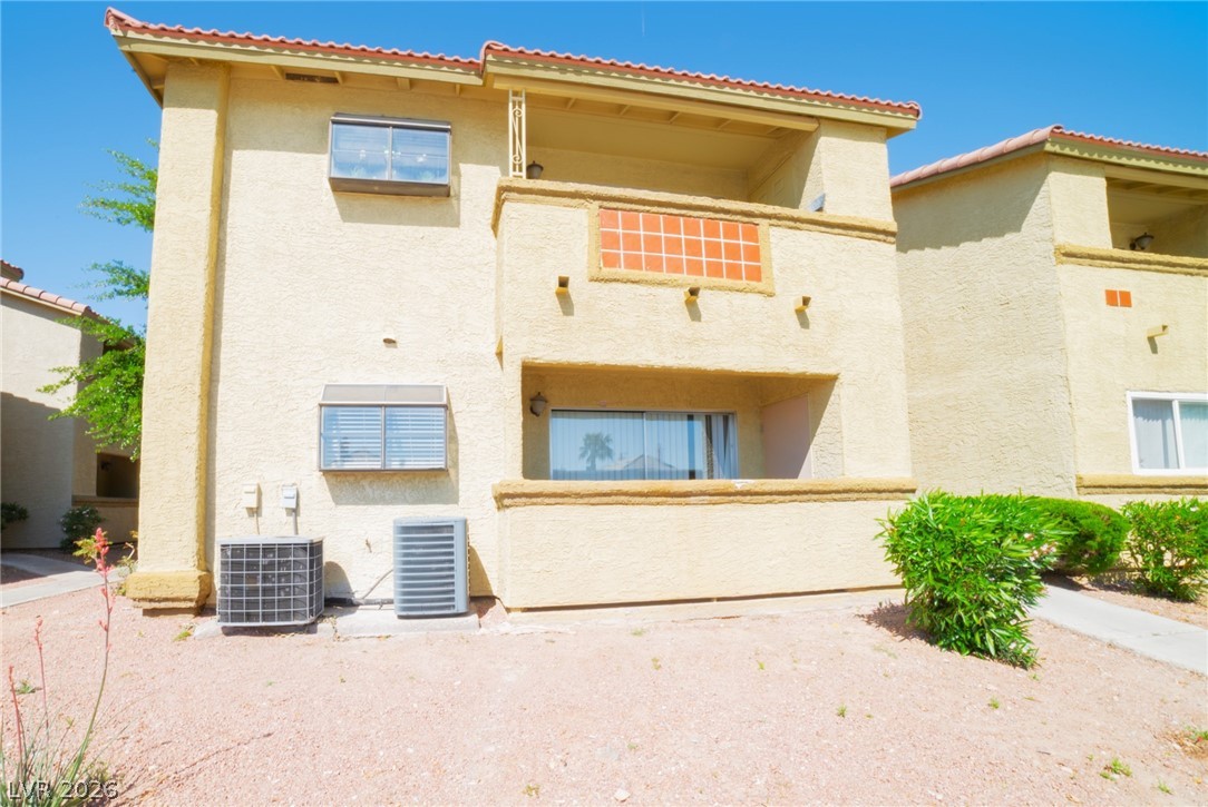 7200 West Pirates Cove Road, Unit 1049 Las Vegas, NV 89145 - Photo 9 of 12 Back of property with stucco siding, a tile roof, and a balcony