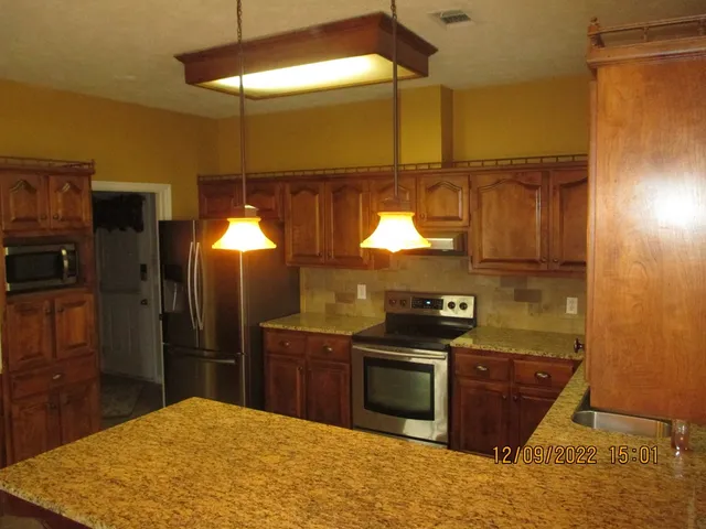 a kitchen with stainless steel appliances granite countertop a sink and cabinets