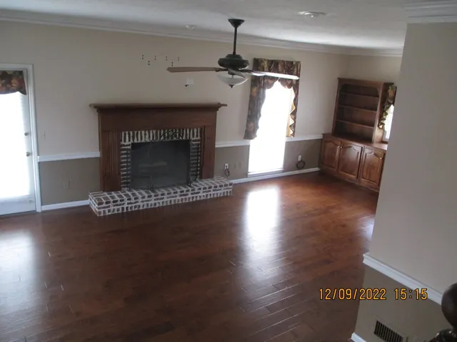 a living room with hard wood floors and a fireplace