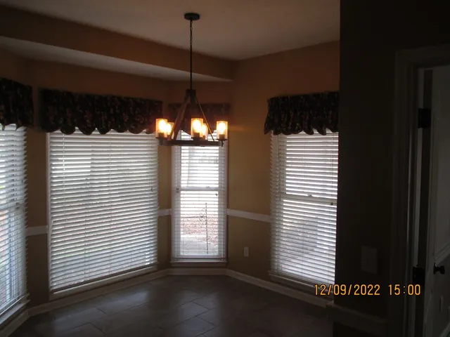 a view of a room with a window and wooden floor