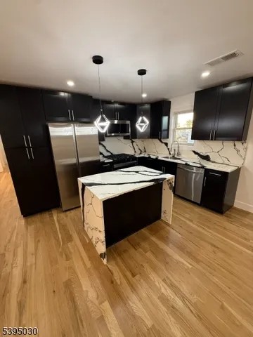a kitchen with stainless steel appliances granite countertop a stove a sink and a microwave