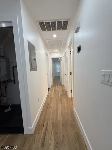 a view of a hallway with wooden floor and staircase