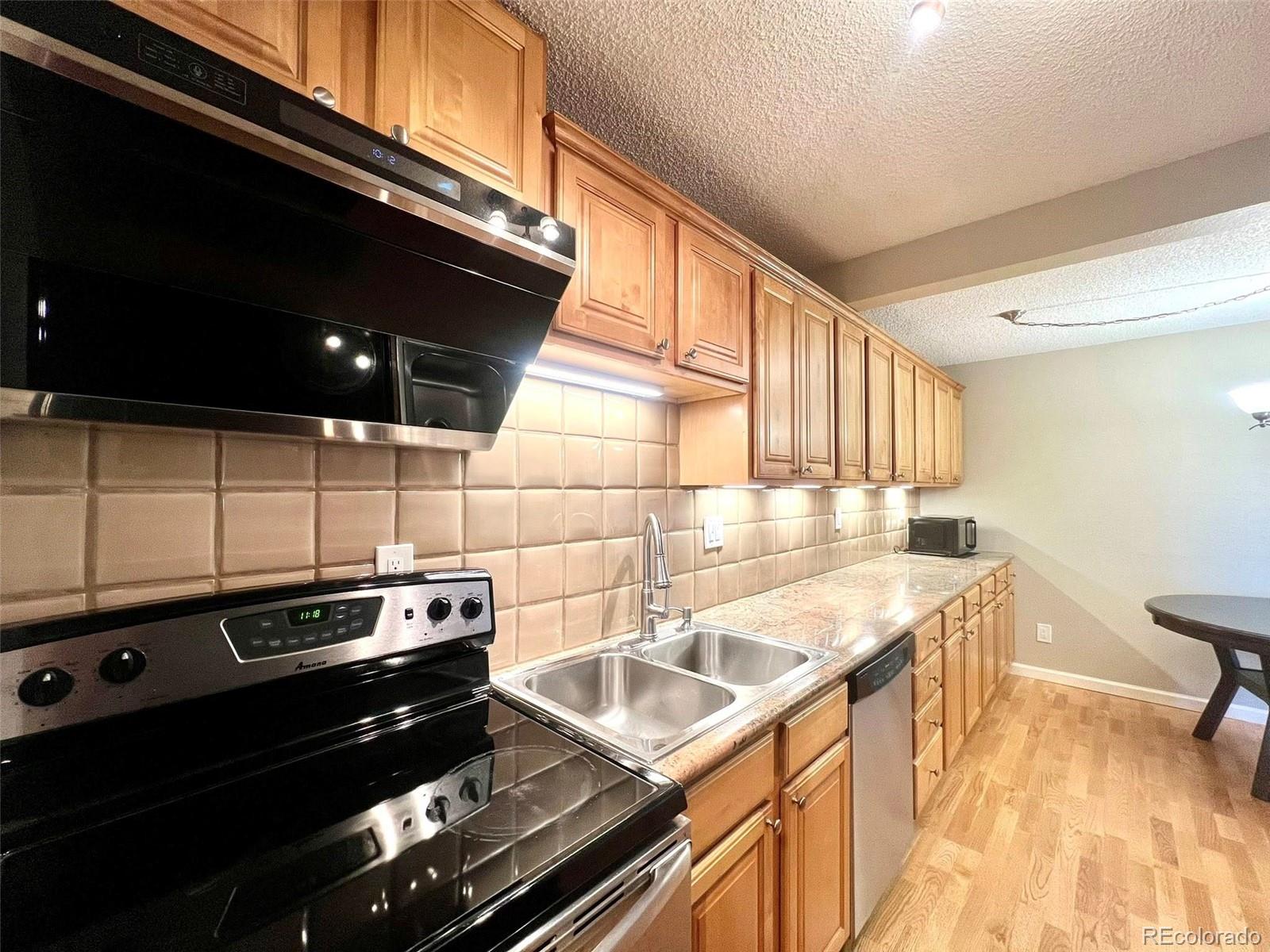 2 Adams Street, Unit 604 Denver, CO 80206 - Photo 13 of 41 a kitchen that has a sink a stove and a microwave