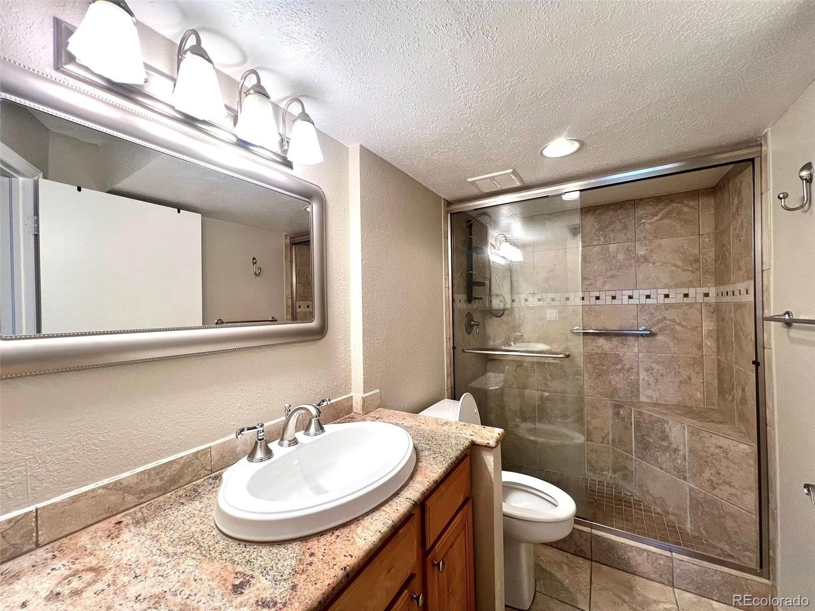 2 Adams Street, Unit 604 Denver, CO 80206 - Photo 14 of 41 a bathroom with a sink a toilet and shower