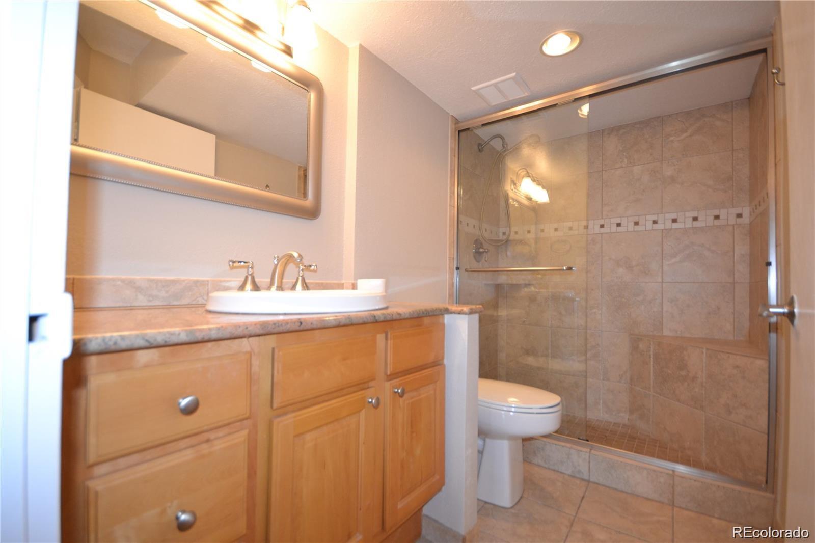 2 Adams Street, Unit 604 Denver, CO 80206 - Photo 16 of 41 a bathroom with a granite countertop sink a toilet and shower