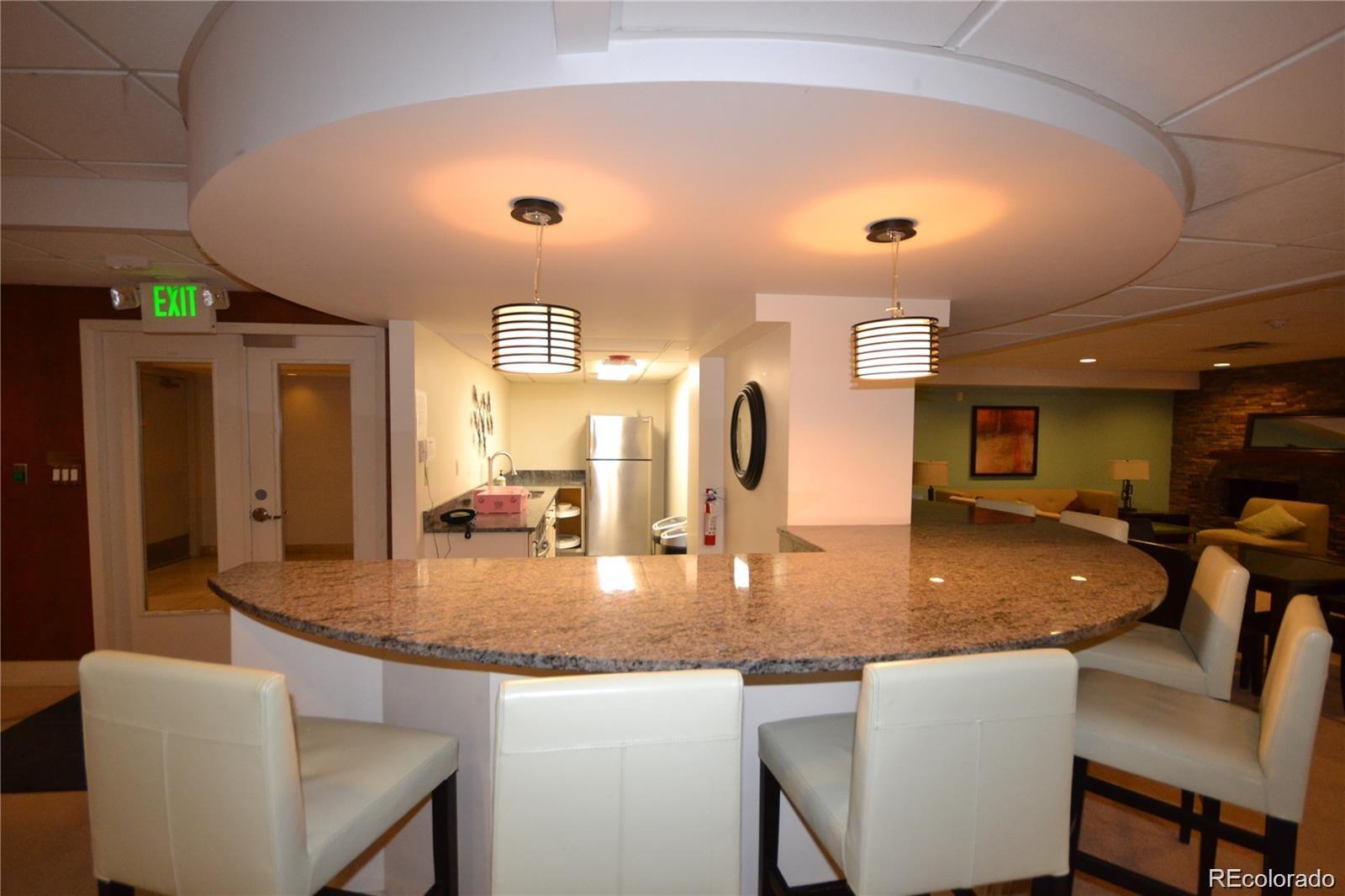 2 Adams Street, Unit 604 Denver, CO 80206 - Photo 24 of 41 a kitchen with center island table chairs in it and a living room
