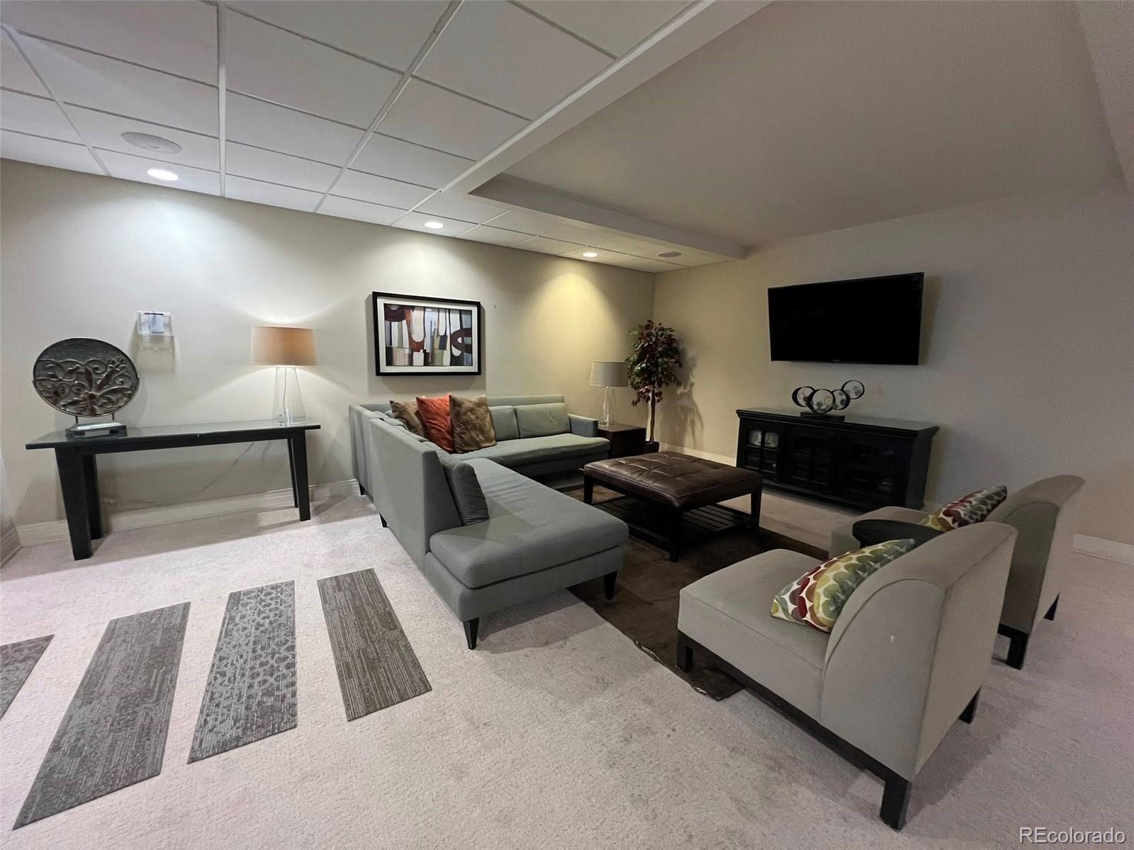 2 Adams Street, Unit 604 Denver, CO 80206 - Photo 33 of 41 a living room with furniture and a flat screen tv