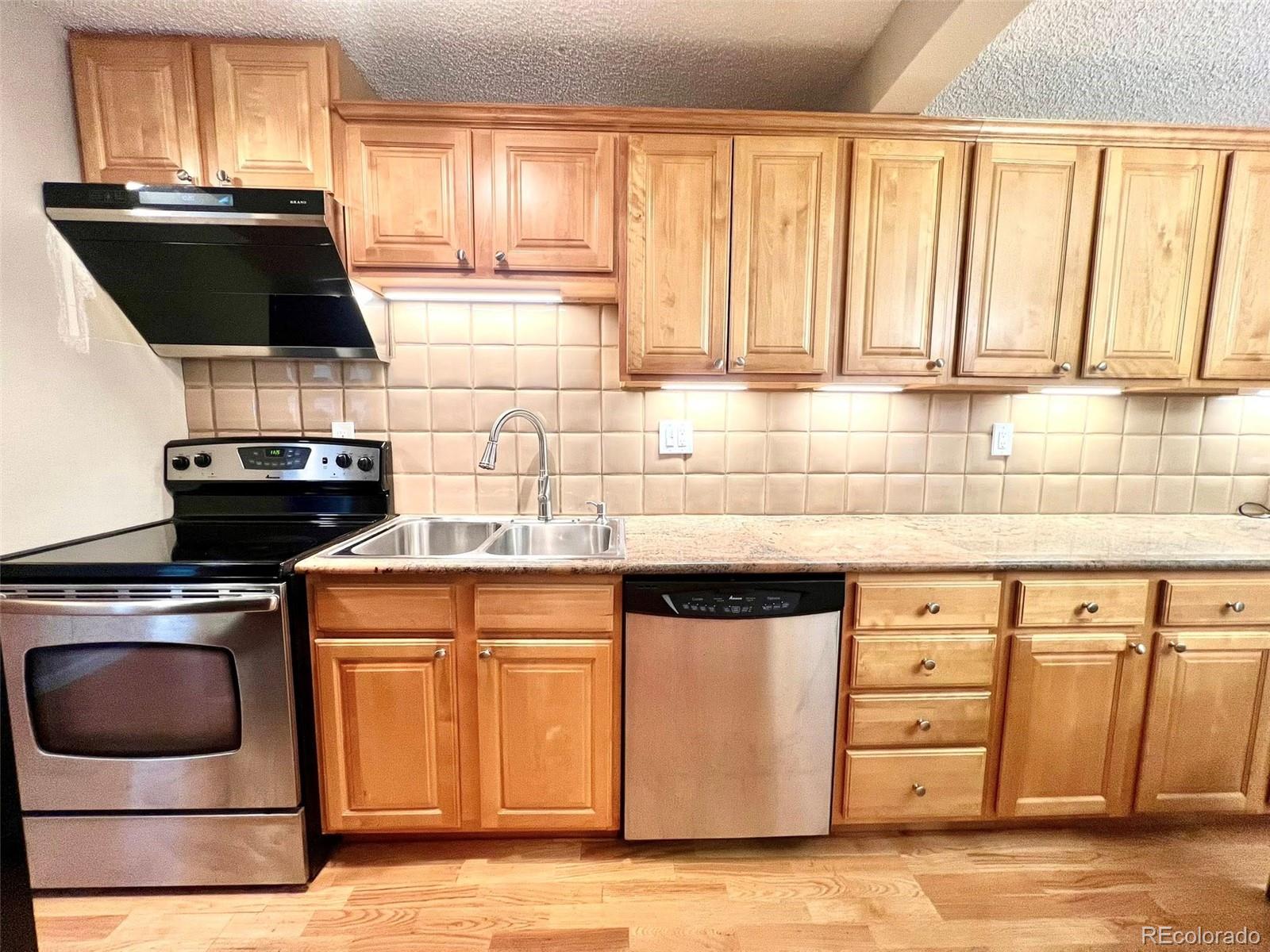 2 Adams Street, Unit 604 Denver, CO 80206 - Photo 10 of 41 a kitchen with a stove and a microwave