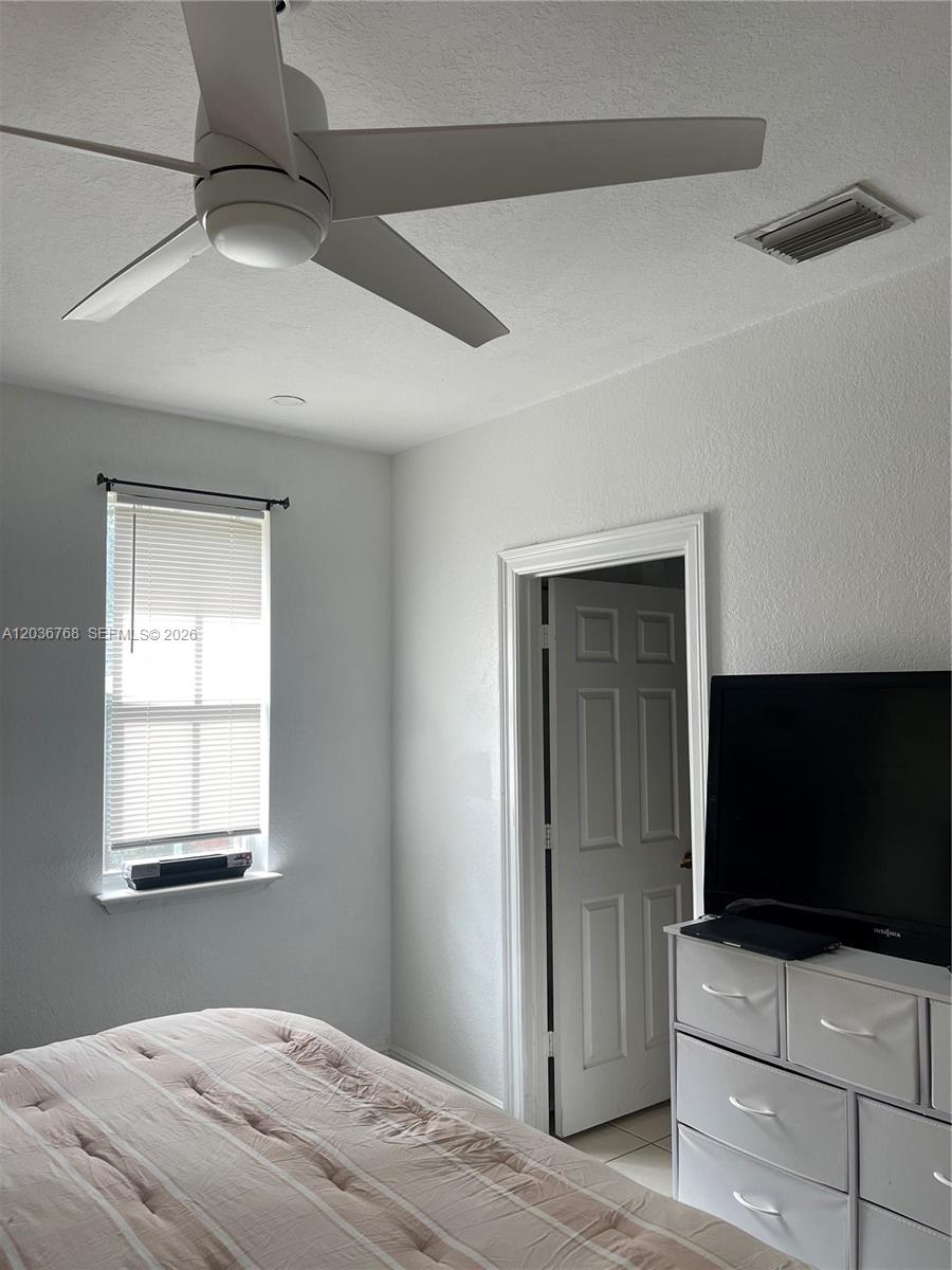 2432 Southwest 99th Way Miramar, FL 33025 - Photo 6 of 17 a bedroom with a bed and flat screen tv