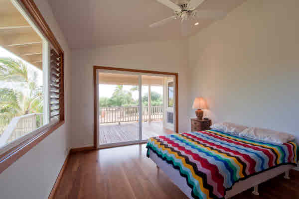 7501 Koolau Road Kilauea, HI 96754 - Photo 8 of 20 a bedroom with a bed and a large window