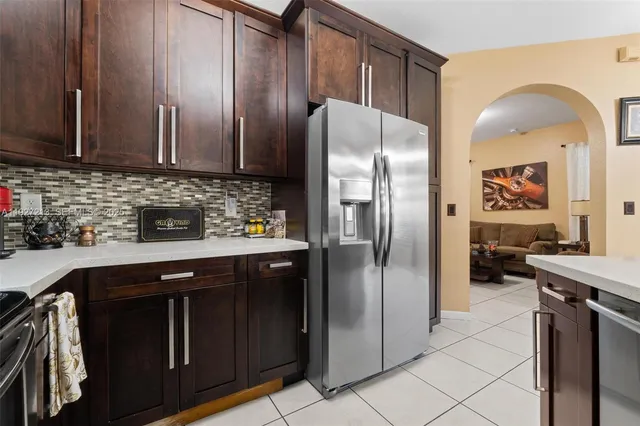 a kitchen with stainless steel appliances granite countertop a refrigerator a sink and wooden cabinets