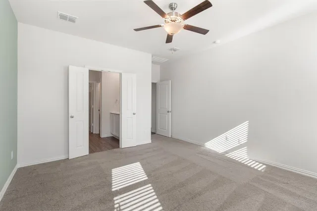 a view of a room with a ceiling fan and a window