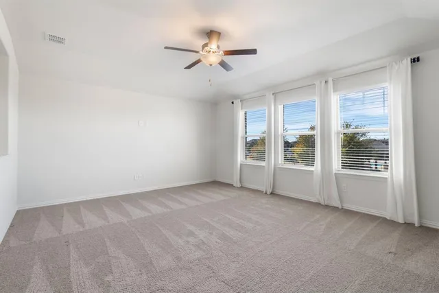 an empty room with a ceiling fan and a window