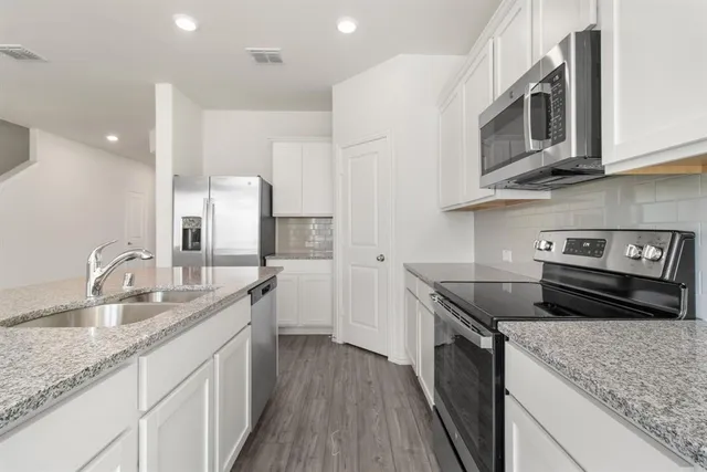 a kitchen with stainless steel appliances granite countertop a sink stove and cabinets