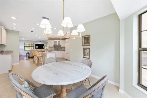 a living room with furniture and kitchen view with wooden floor