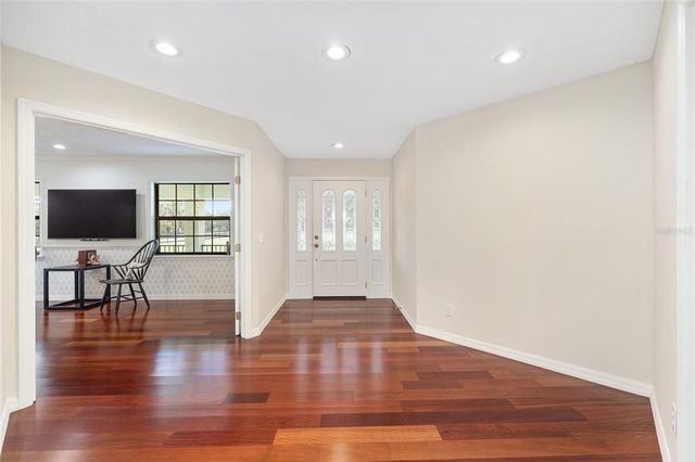 a view of a livingroom with wooden floor and furniture