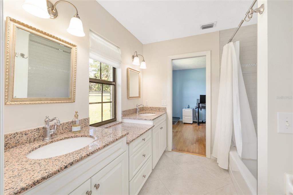 8778 Northwest 130th Street Reddick, FL 32686 - Photo 32 of 88 a bathroom with a granite countertop double vanity sink and a mirror