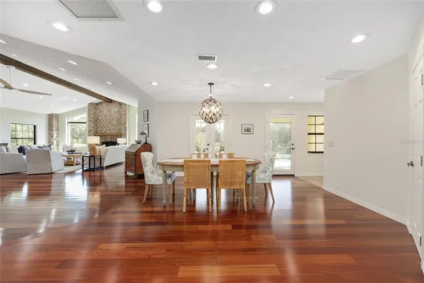 an open kitchen with dining table wooden floor and a view of living room