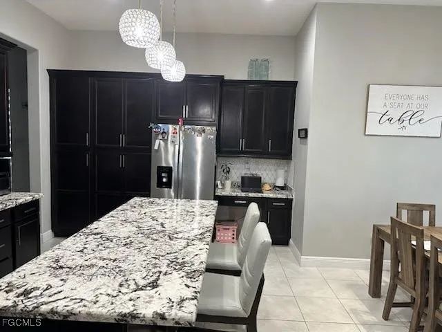 a kitchen with stainless steel appliances kitchen island granite countertop a refrigerator and a stove top oven