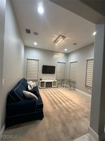 a spacious bedroom with a bed a flat screen tv and a couch