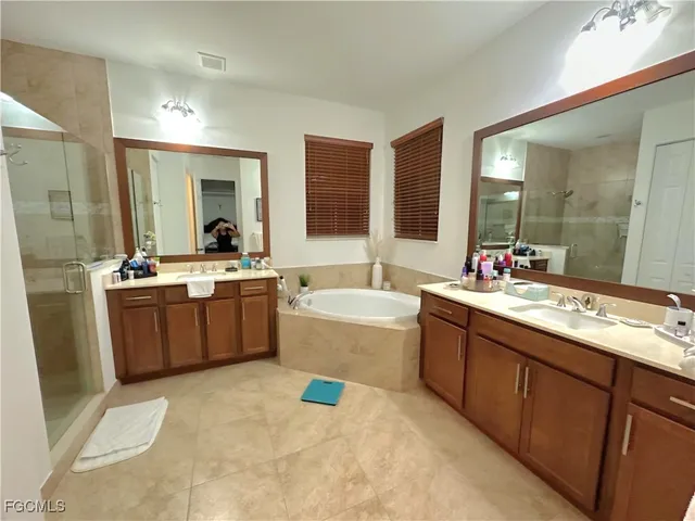 a large bathroom with a tub double vanity sink and mirror
