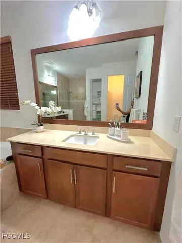 a bathroom with a granite countertop sink and a mirror