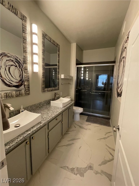 700 Carnegie Street, Unit 4112 Henderson, NV 89052 - Photo 12 of 21 Bathroom featuring double vanity, a stall shower, and light marble finish floors