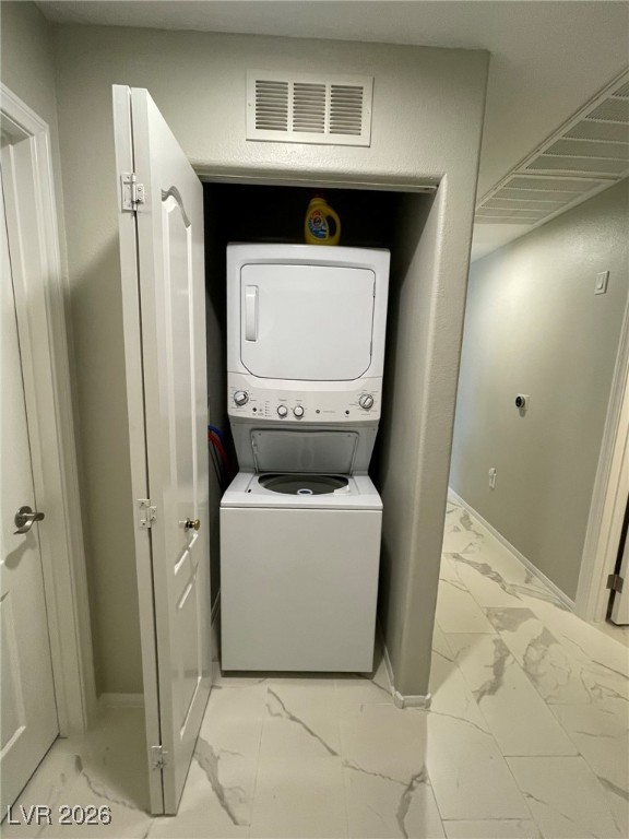 700 Carnegie Street, Unit 4112 Henderson, NV 89052 - Photo 13 of 21 Laundry room with light marble finish floors and stacked washer and clothes dryer
