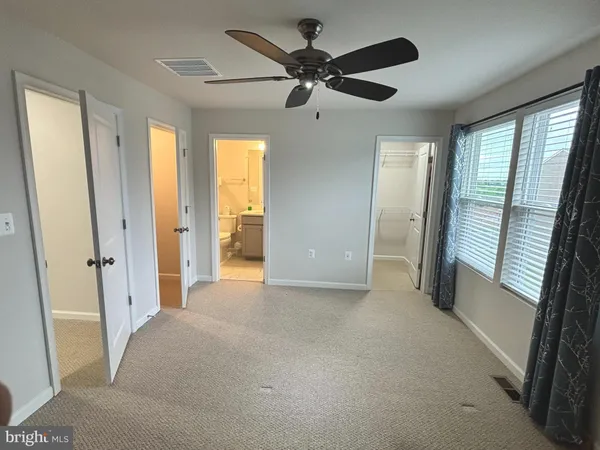 a view of an empty room and a ceiling fan