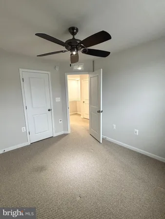 a view of an empty room and a ceiling fan