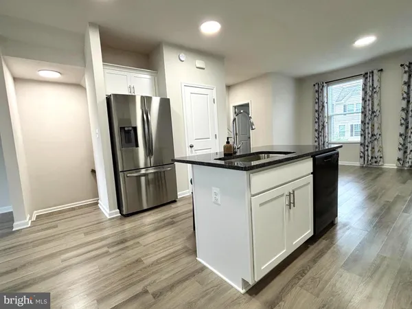 a kitchen with stainless steel appliances granite countertop a refrigerator a sink and a stove