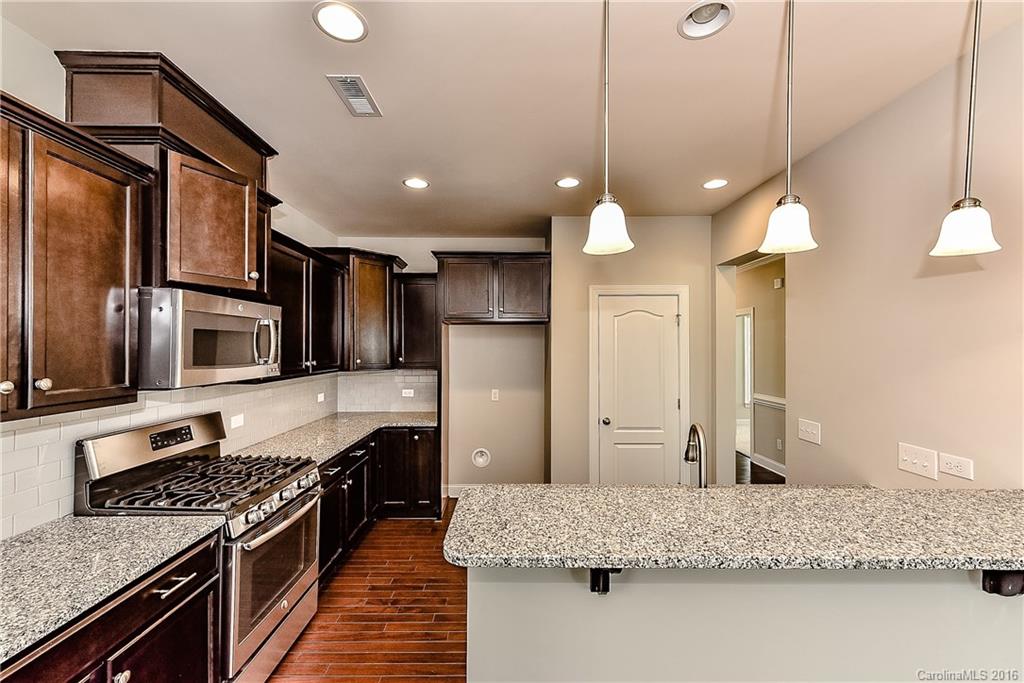 5157 Waterloo Drive, Unit CC151 Tega Cay, SC 29708 - Photo 8 of 21 a kitchen with kitchen island granite countertop a stove and a sink