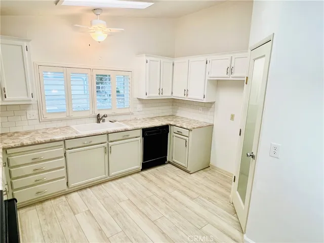 a kitchen with a sink a window and cabinets