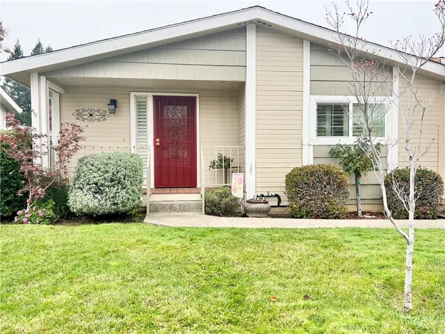a view of house with backyard and glass windows