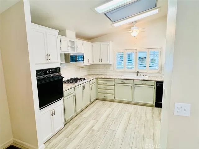 a kitchen with stainless steel appliances a white stove top oven sink and cabinets