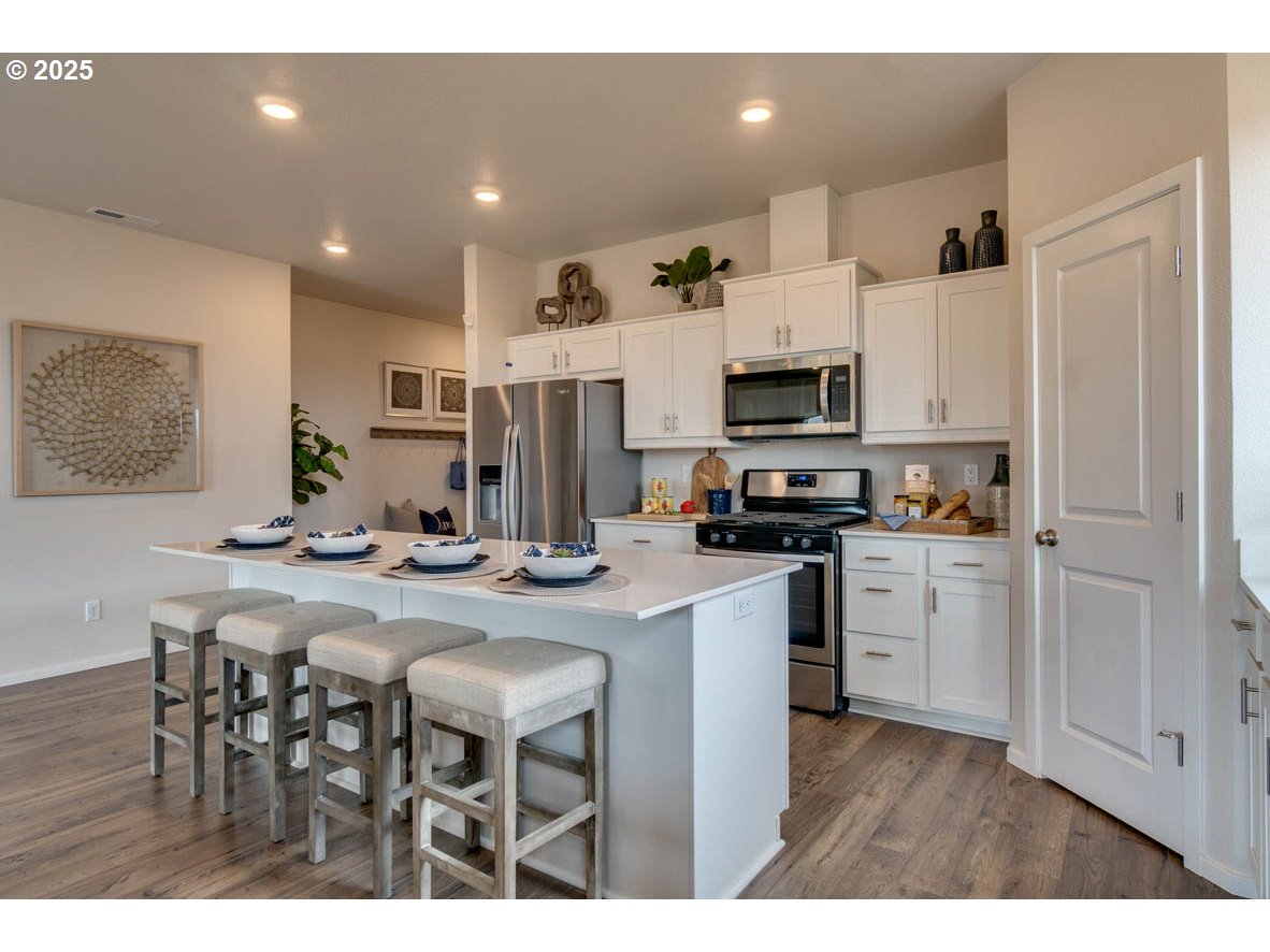 2934 U Street Springfield, OR 97477 - Photo 9 of 21 a kitchen with stainless steel appliances granite countertop a stove a sink a microwave a refrigerator and white cabinets