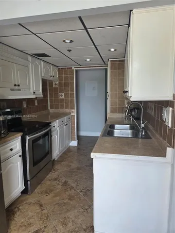 a view of washer and dryer with kitchen in the background