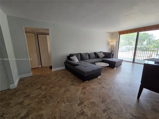 a living room with furniture and a floor to ceiling window