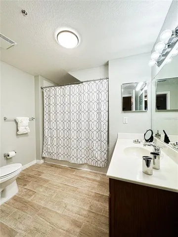 a bathroom with a sink toilet double vanity and shower