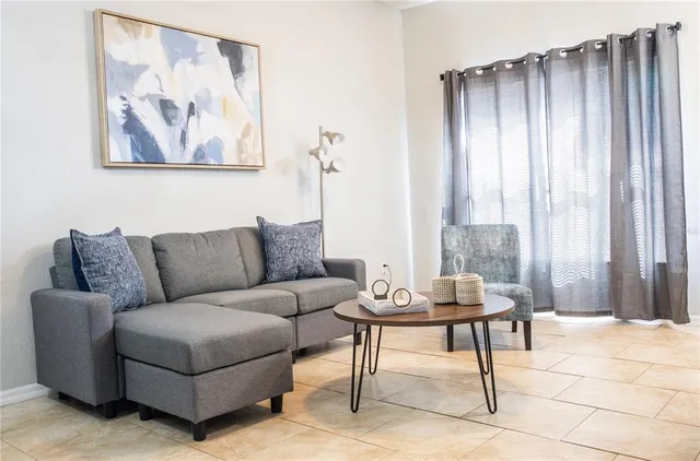 a living room with furniture and a potted plant