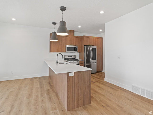 130 East 7085th South, Unit 3 Midvale, UT 84047 - Photo 2 of 30 Kitchen with wood finish cabinetry, pendant lighting, modern cabinets, stainless steel appliances, and light wood-style floors