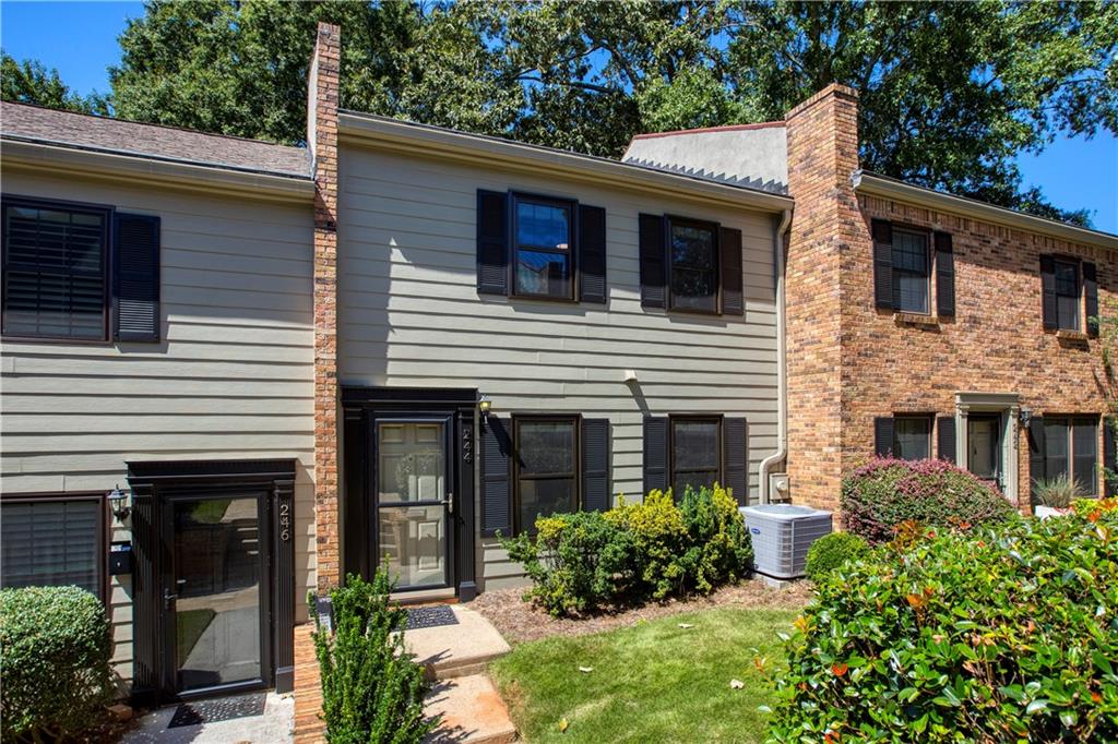 a view of a house with potted plants and a table and chairs