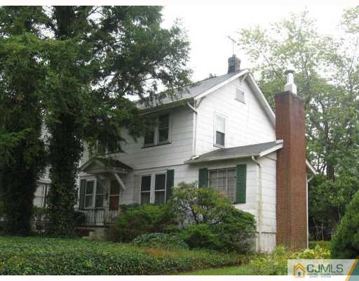 a front view of a house with a yard and trees
