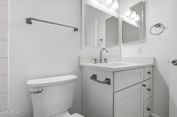 a bathroom with a sink mirror vanity and toilet