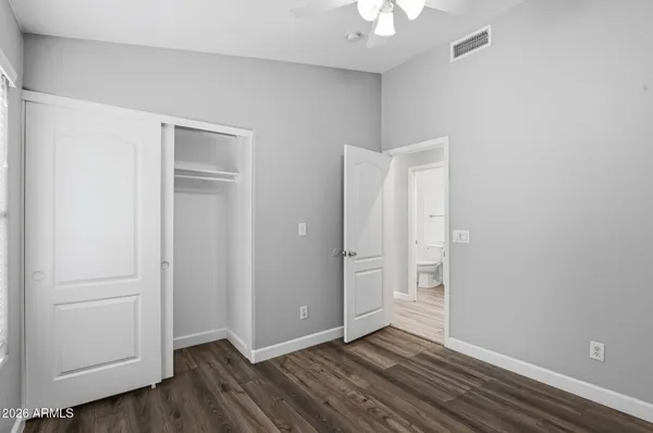 an empty room with wooden floor and closet area