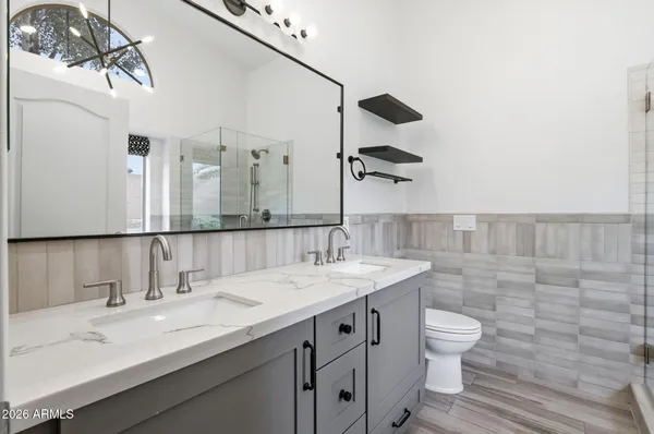 a bathroom with a sink a toilet and mirror