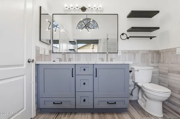 a bathroom with a sink a toilet and a mirror