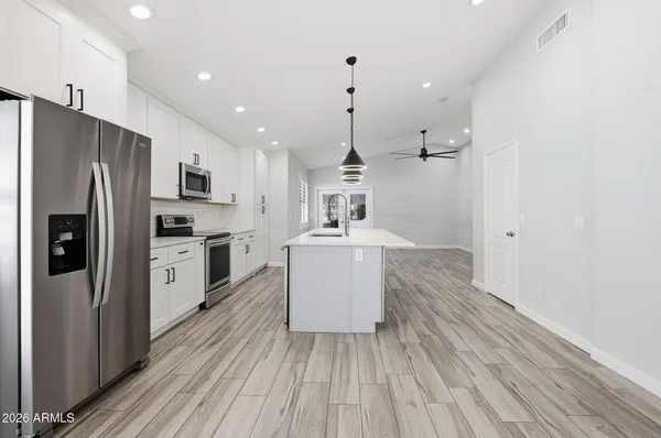 a kitchen with a refrigerator a sink and dishwasher a oven with wooden floor